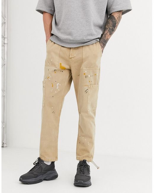 Bershka tapered worker jeans in tan with paint splatter-