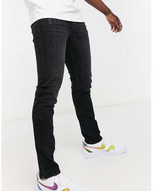 Guess slim tapered jeans in wash with logo