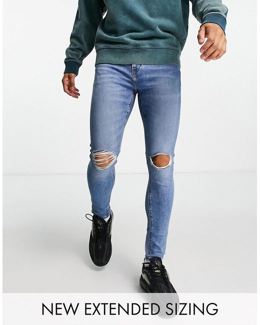 Asos Design spray on jeans with power stretch in mid wash knee rips-