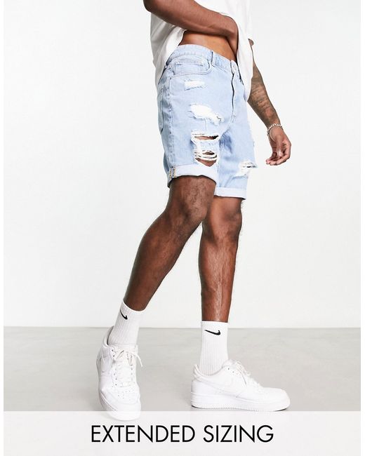 Asos Design slim mid length denim shorts with heavy rips in light wash