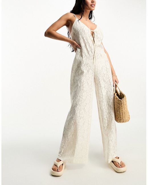 Asos Design lace beach jumpsuit with cut out in cream-