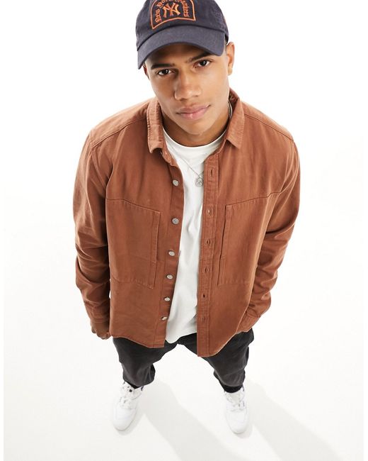 Asos Design denim overshirt with side oversized pockets and buttons tan-